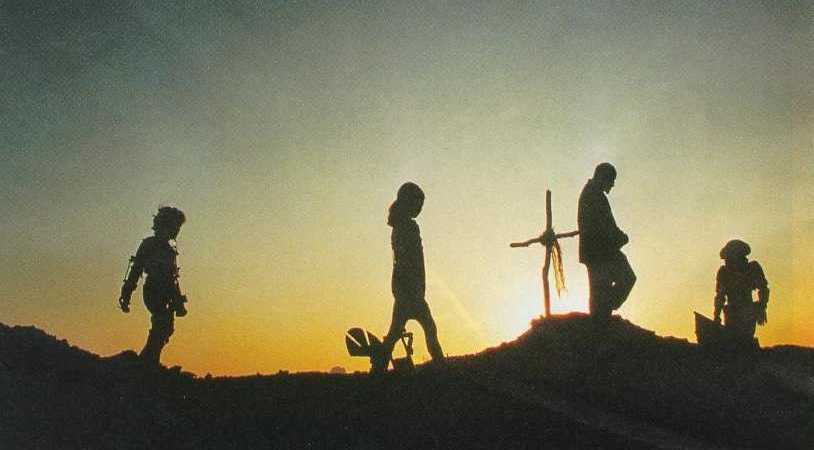 True Danziger, Ulysses Adair, Yale, Zero, in silhouette, standing by a grave at sunset